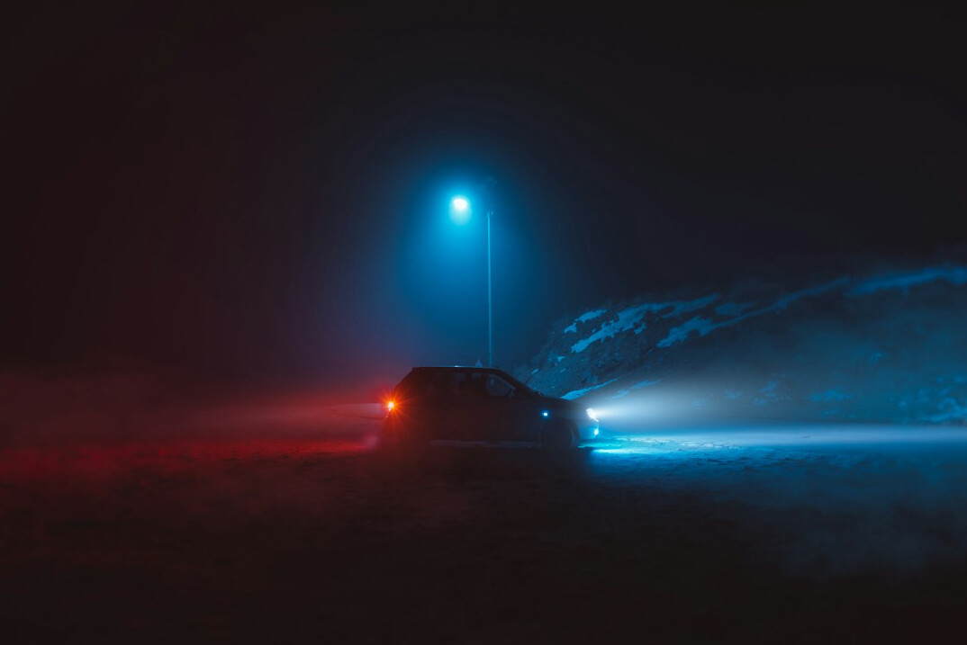 Car driving on a road at night with bright headlights